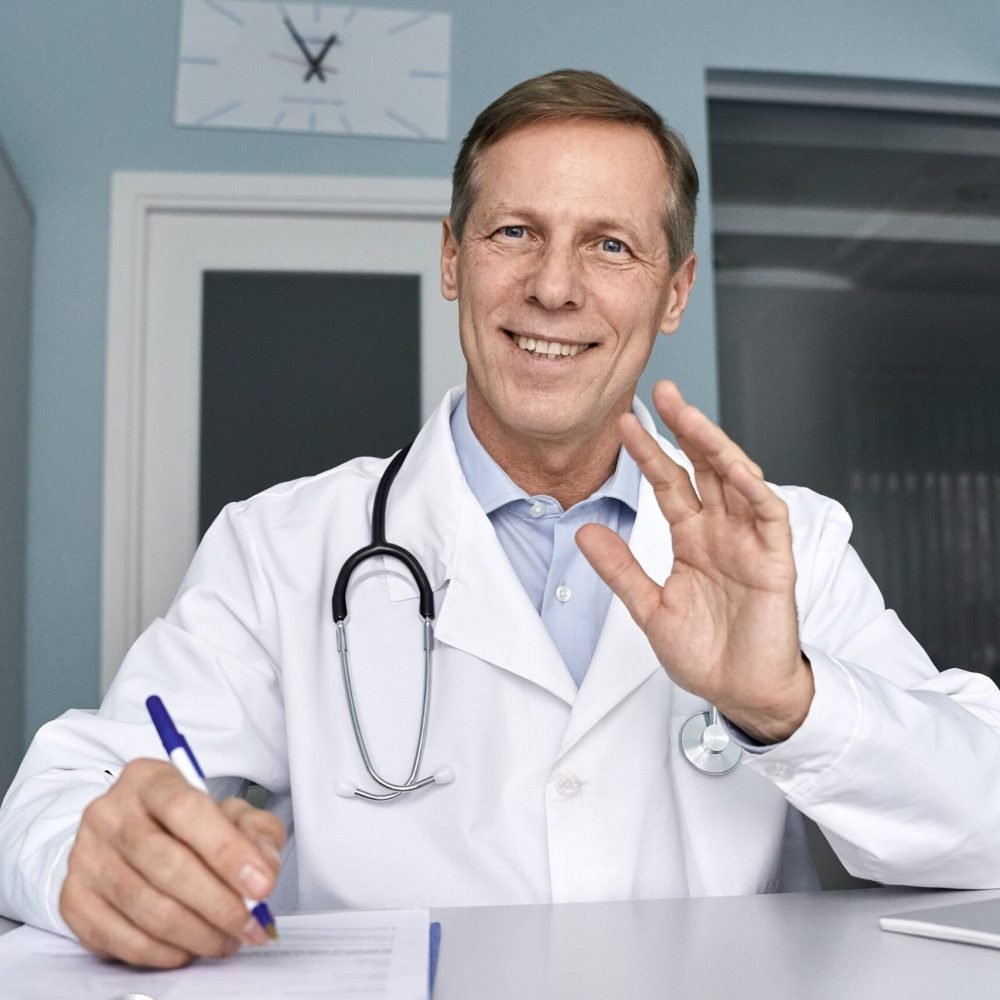 happy-old-male-doctor-talking-during-telehealth-vi-2022-02-06-06-25-09-utc-min